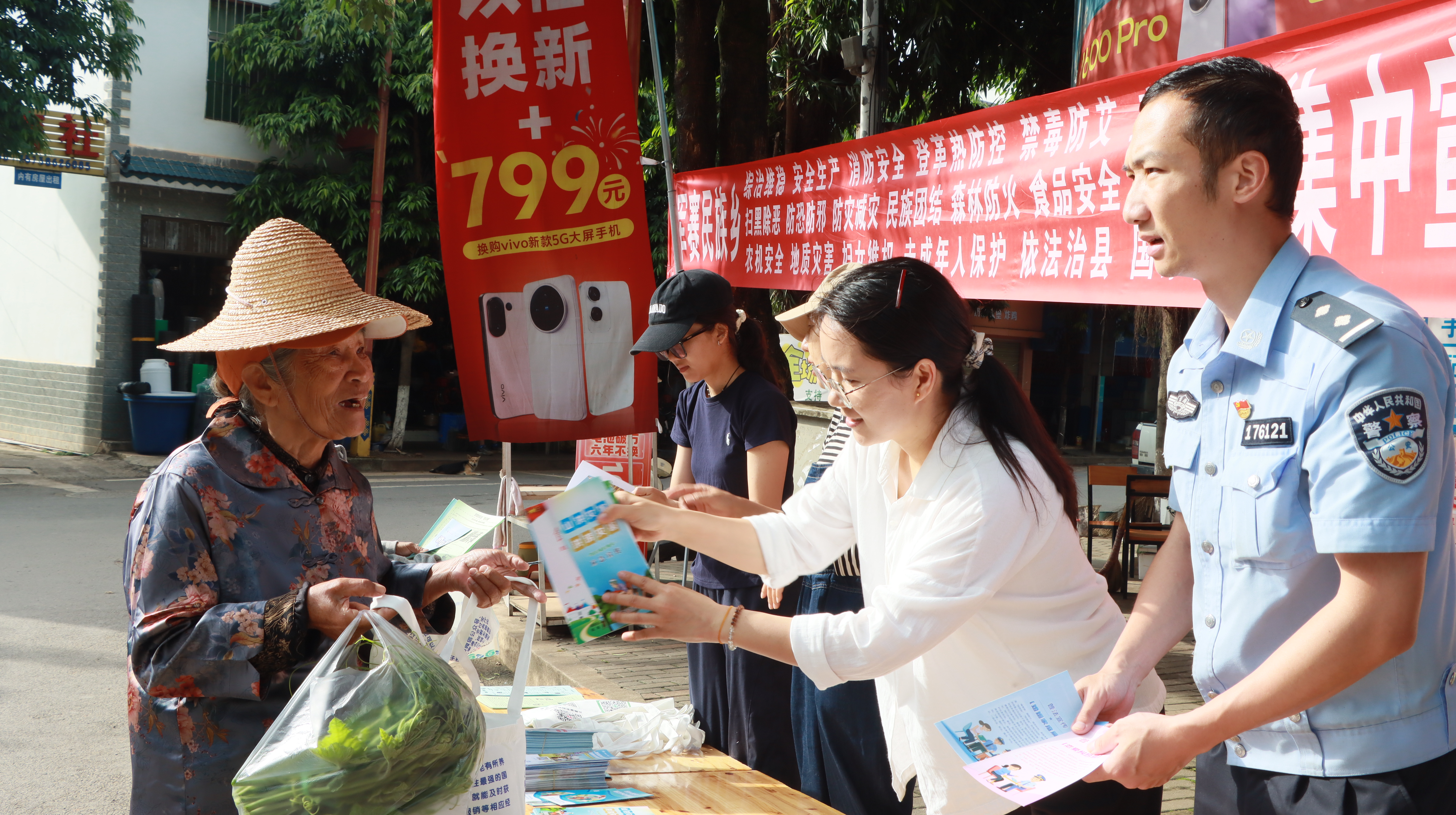 图为向过往的老人解读惠民政策.jpg